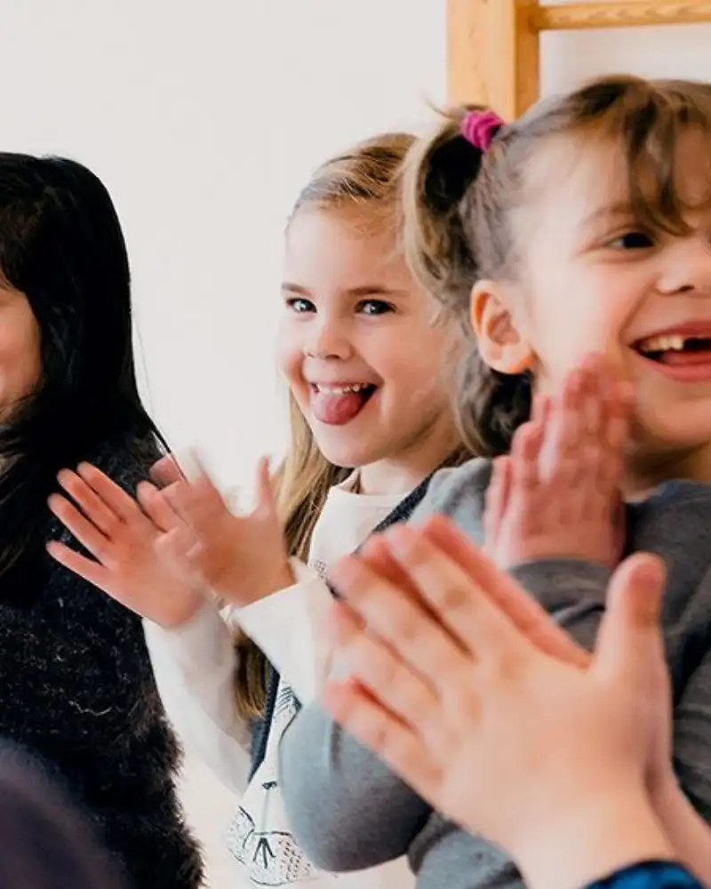 Mehrere Kinder stehen nebeneinander und klatschen in die Hände.