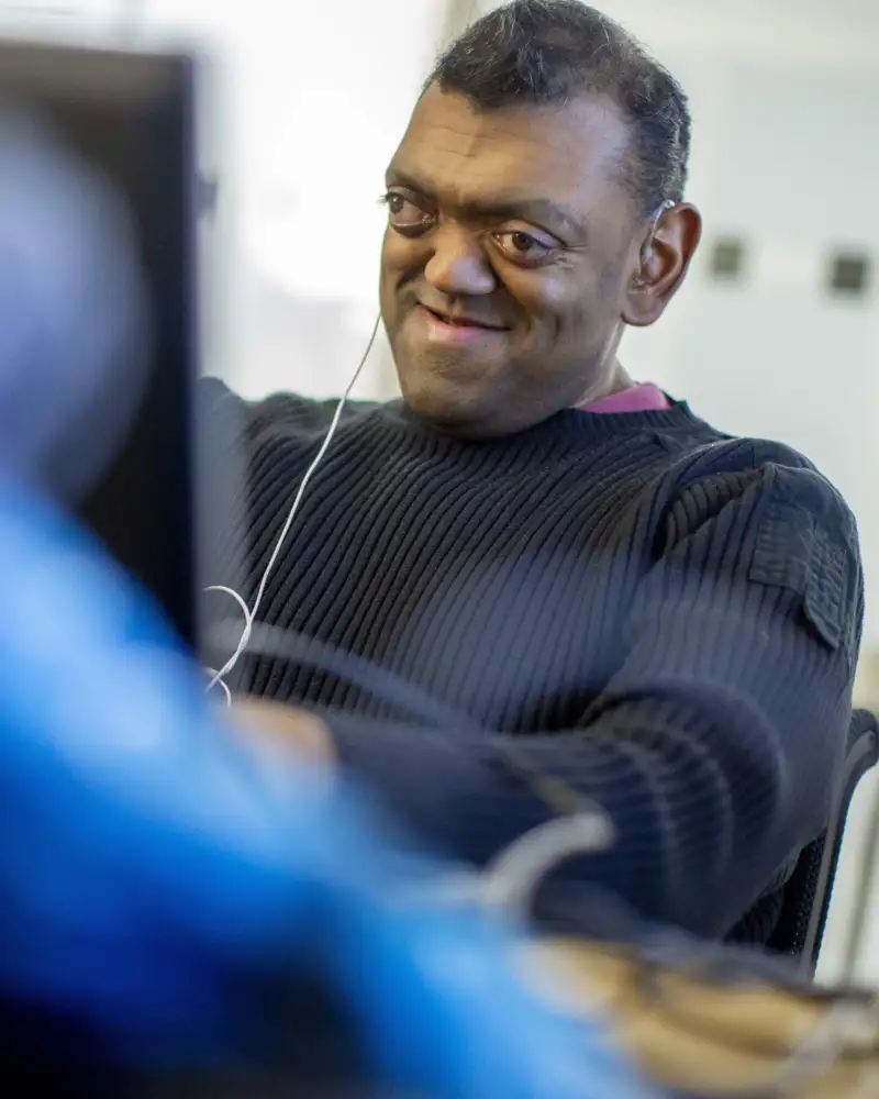 Ein blinder Mann arbeitet am Laptop