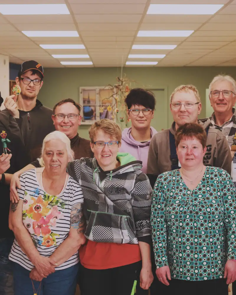 Eine Gruppe von Menschen mit und ohne Behinderung schaut in die Kamera