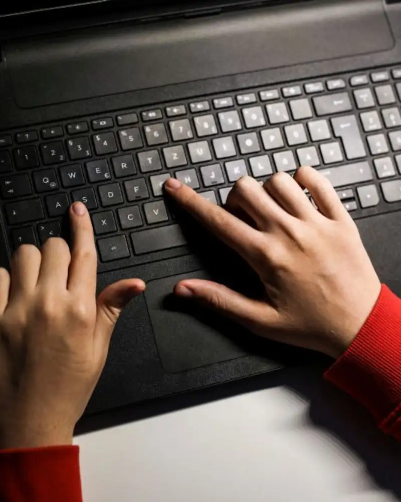 Zwei Hände schreiben auf einer Tastatur.