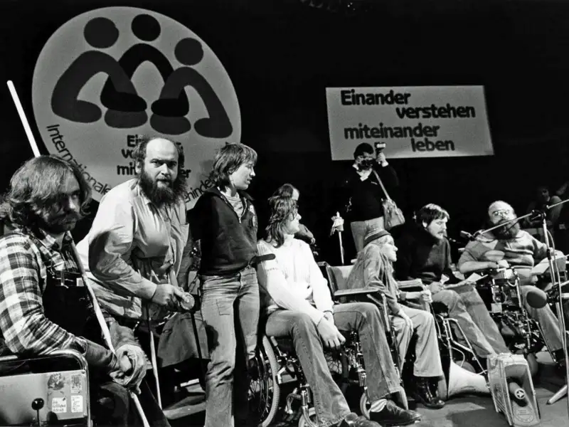 Protestaktion bei der Eröffnungsveranstaltung zum „Jahr der Behinderten“ 1981 in der Dortmunder Westfalenhalle. Aktivist*innen mit Behinderung stürmen die Bühne.