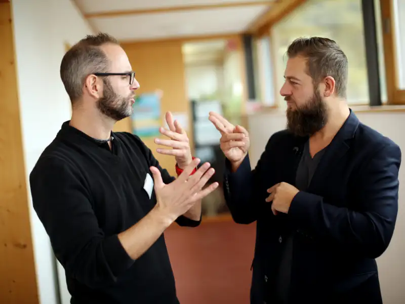 Zwei Menschen unterhalten sich in Gebärdensprache.