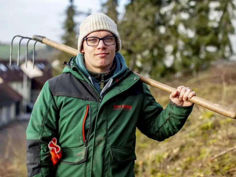 Ein Mann mit einer Gartenhacke bei der Gartenarbeit.