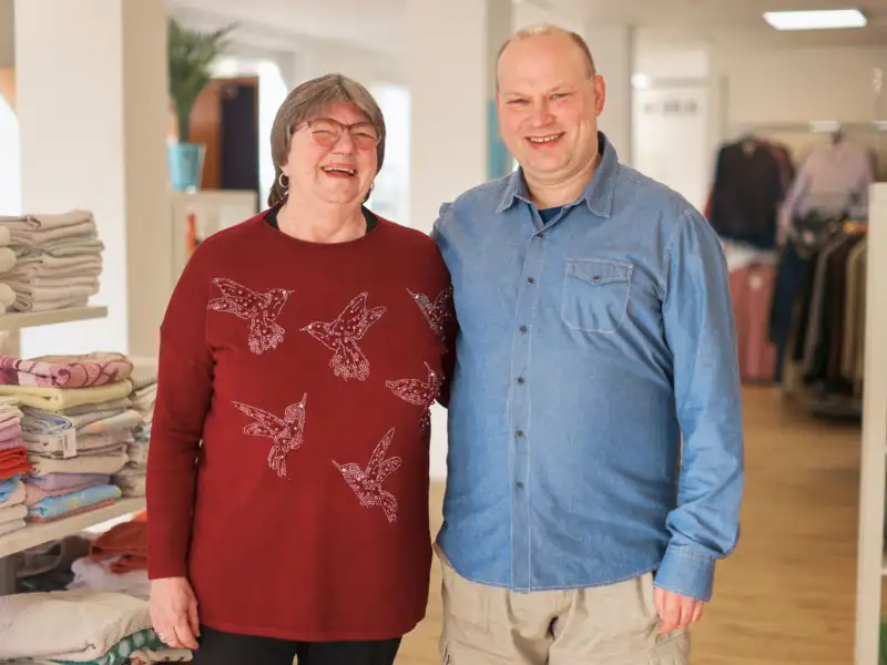 Eine Frau und ein Mann lachen in die Kamera