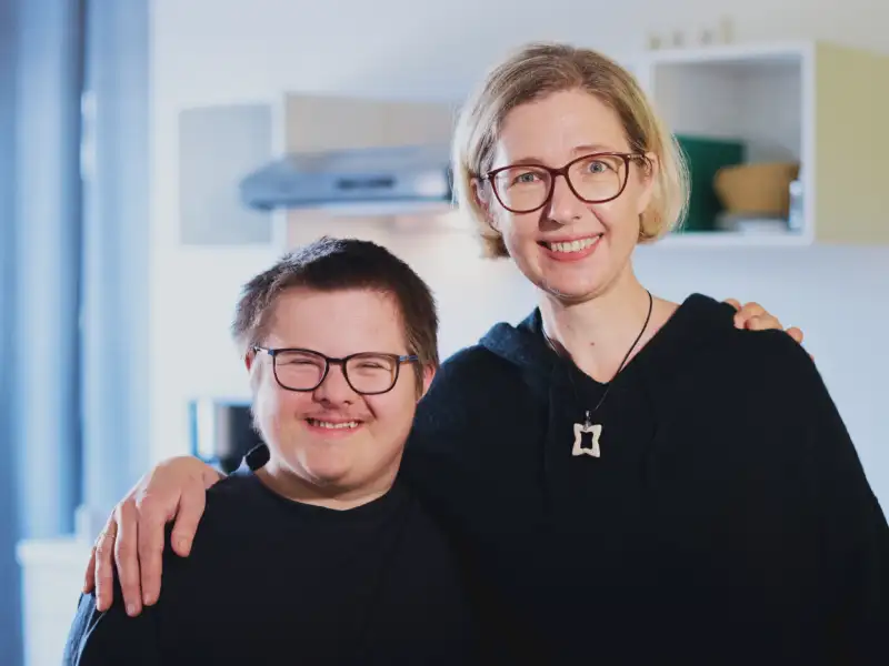 Ein junger Mann und eine junge Frau lächeln in die Kamera.