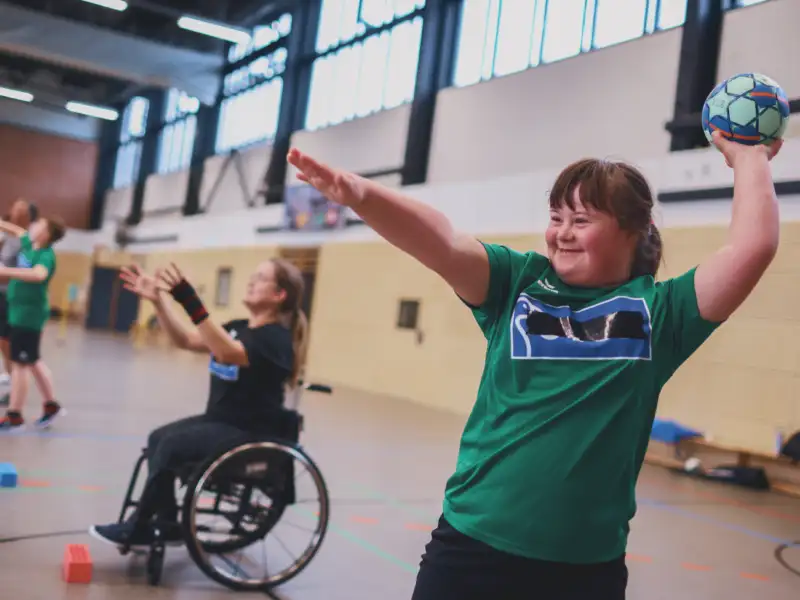 Menschen mit unterschiedlichen Behinderungen und Menschen ohne Behinderung machen zusammen Sport.