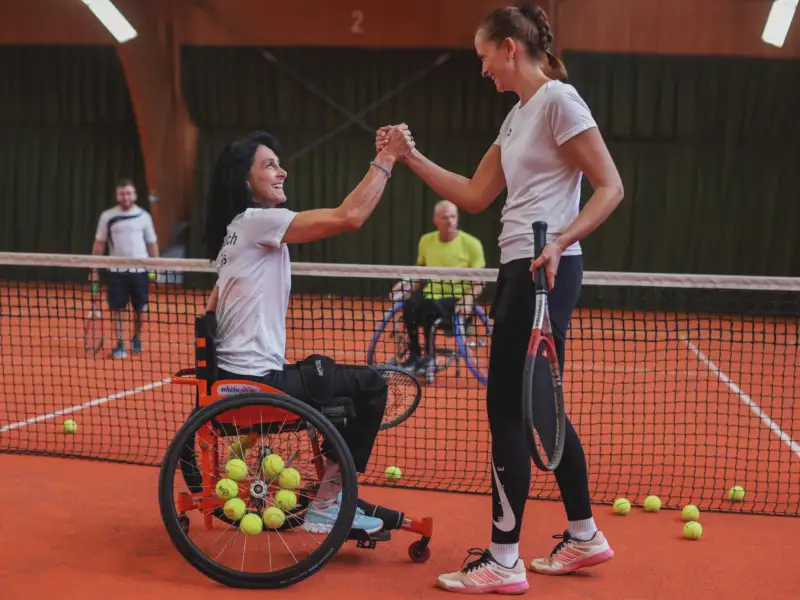 Ein gemischtes Doppel im Tennis mit Fußgänger:innen, Rollstuhl-Fahrer:innen, Männern und Frauen