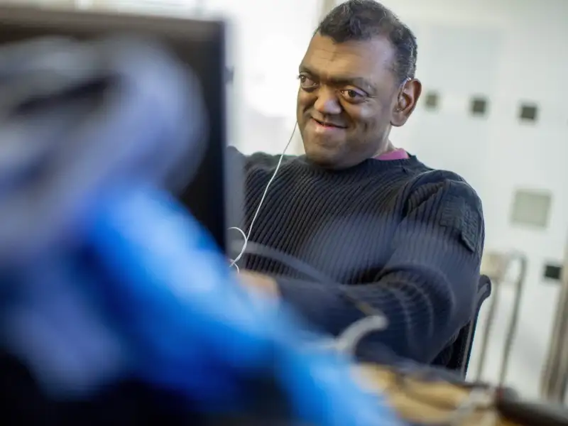 Ein blinder Mann arbeitet am Laptop