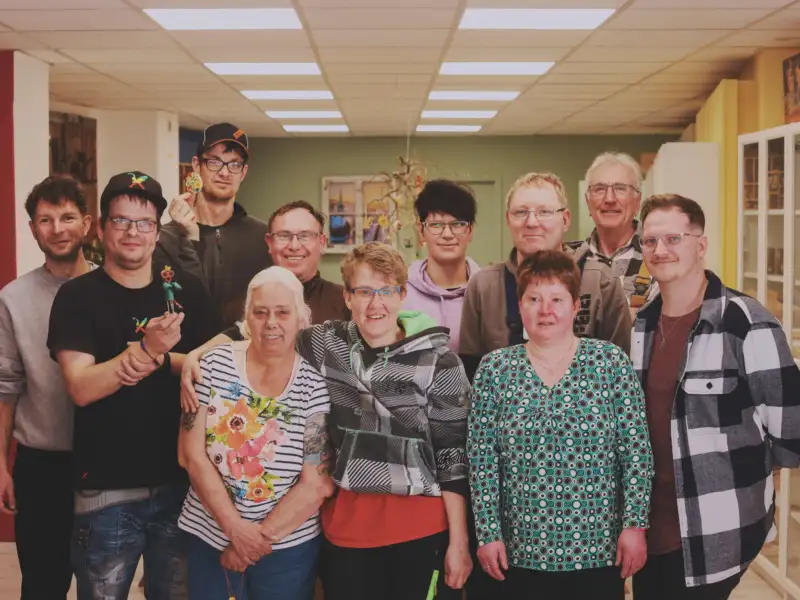 Eine Gruppe von Menschen mit und ohne Behinderung schaut in die Kamera