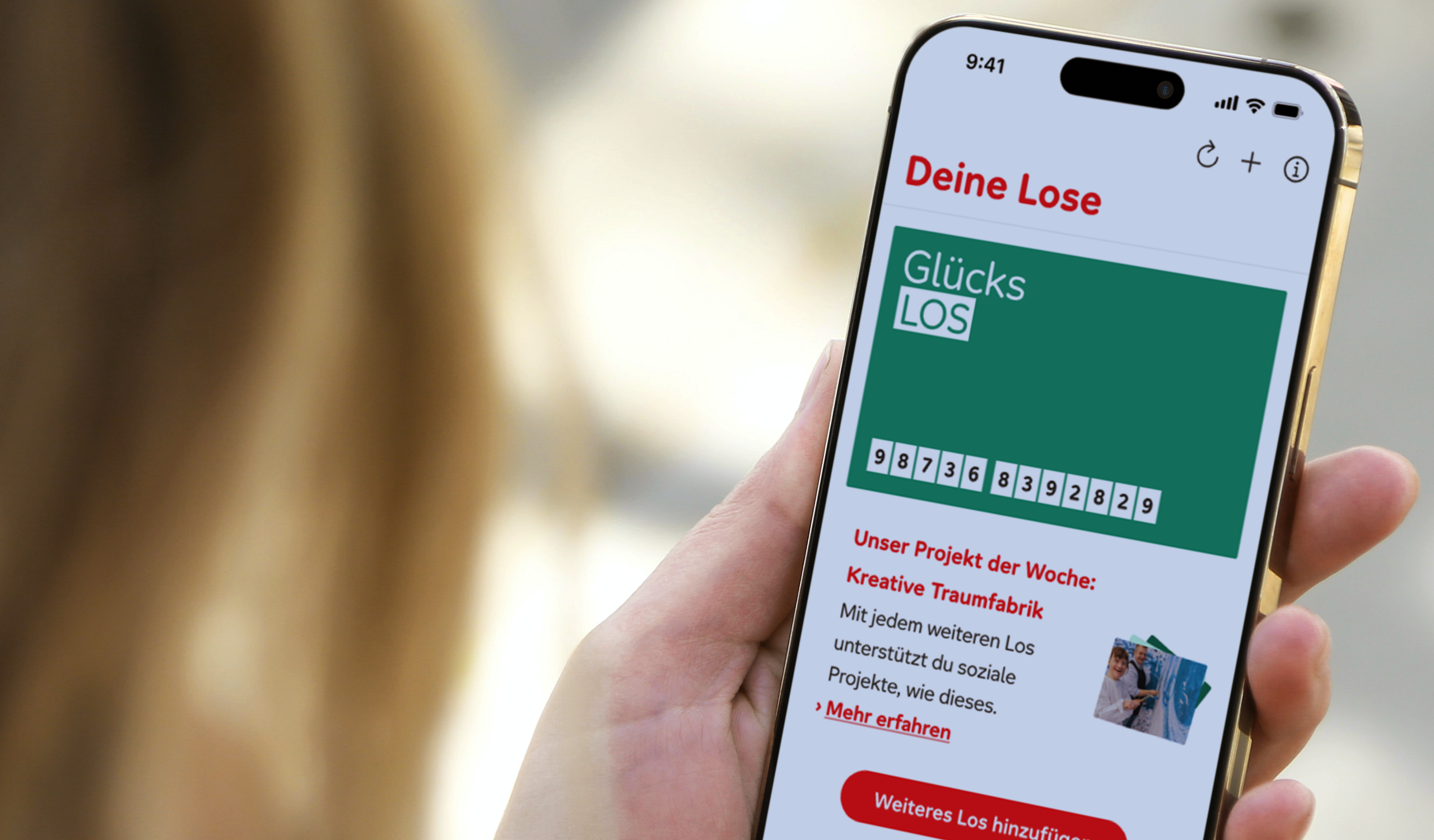 Auf einem Mobiltelefon ist die App der Aktion Mensch geöffnet. Darin ist das grüne Glücks-Los der Aktion Mensch zu sehen.