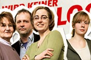 Vier Menschen vor einem Plakat