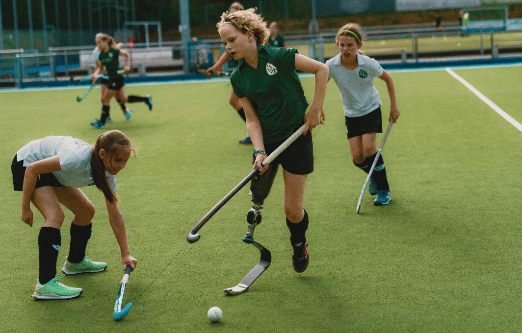 Eine Hockeymannschaft aus jungen Mädchen spielt auf dem Platz.