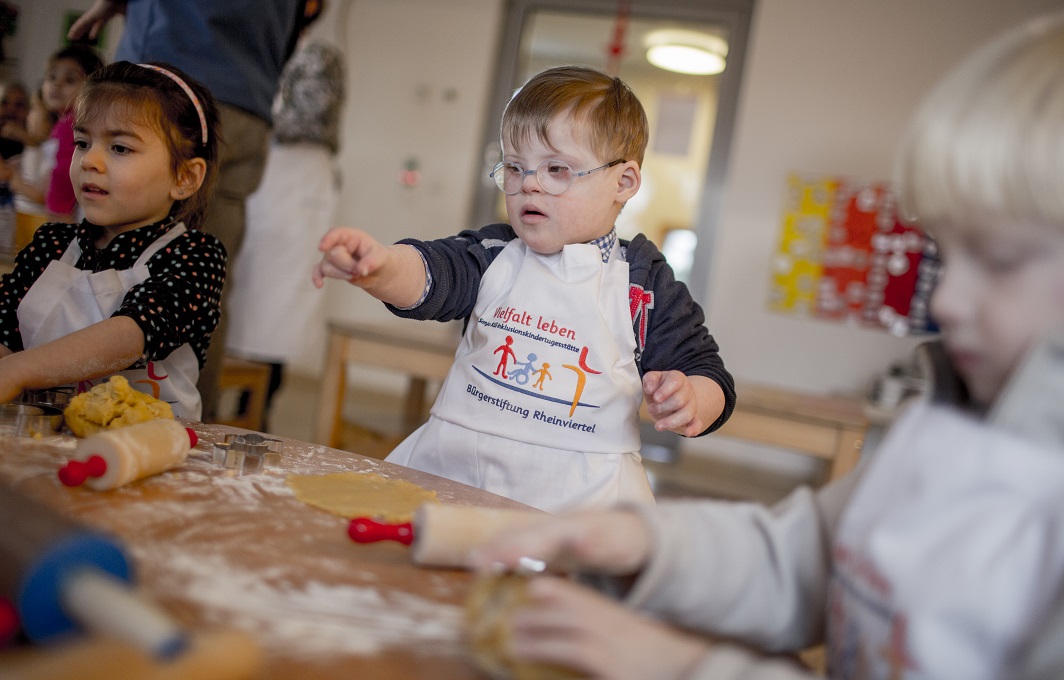 Kinder mit und ohne Behinderung backen zusammen.