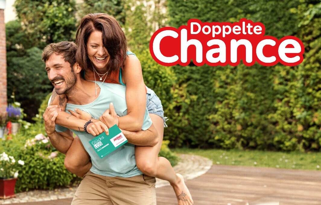 Ein Mann nimmt eine Frau Huckepack. Auf einem Logo steht: Doppelte Chance