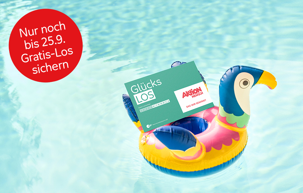 Eine Schwimmente schwimmt mit einem Glücks-Los auf dem Pool.