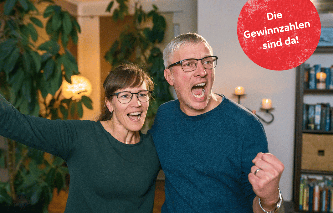 Eine Frau und ein Mann halten sich im Arm, machen eine Jubel-Geste und haben den Mund zum Freudenschrei weit aufgerissen. Text: Die Gewinnzahlen sind da!