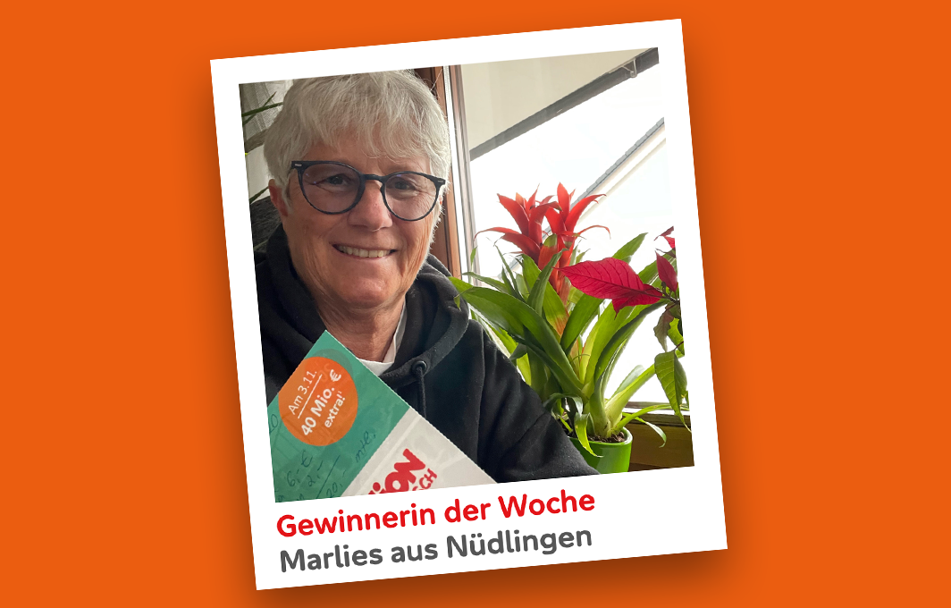 Die Gewinnerin Marlies hält ihr Los in die Kamera und lacht dabei.