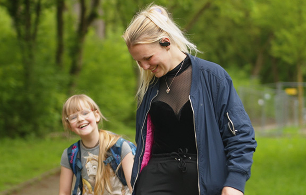 Jenny hat Karina an der Hand. Beide lachen.
