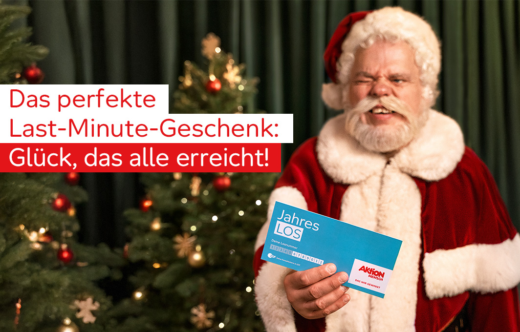 Ein Weihnachtsmann hält das Jahreslos in der Hand.