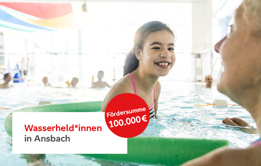 Ein Mädchen mit Behinderung schwimmt mit einer Schwimmnudel.