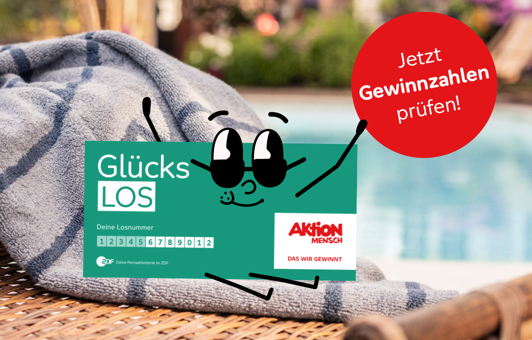 Ein Glücks-Los sitzt am Pool und hebt die Arme hoch.