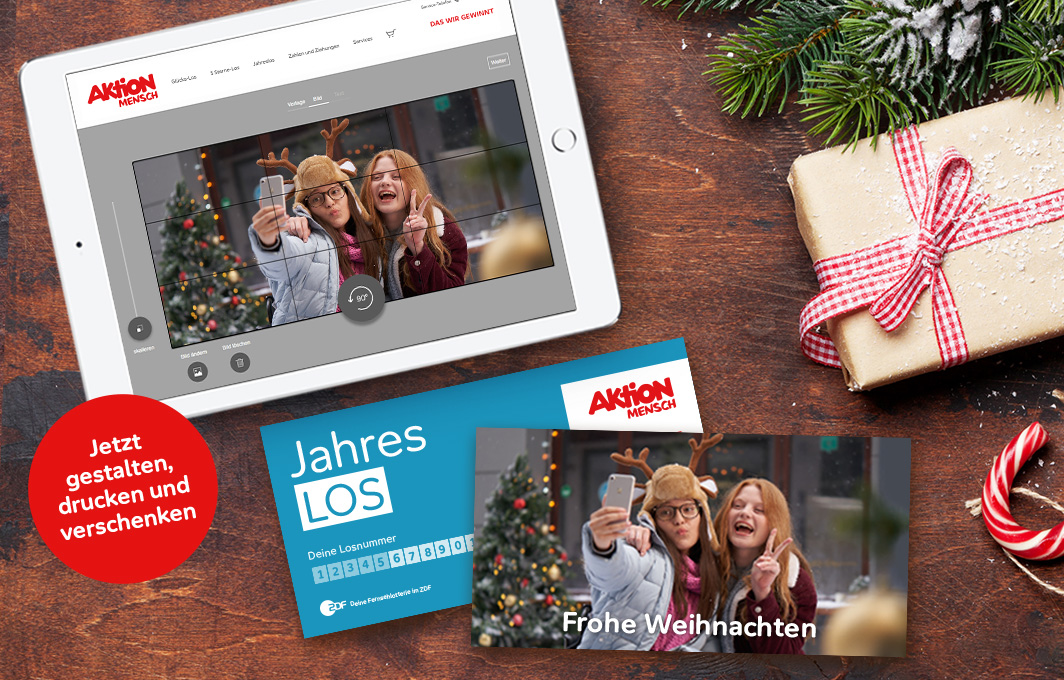 Auf einem Ipad wird ein Jahreslos mit persönlichem Foto gestaltet. Daneben liegt das fertige Jahreslos.