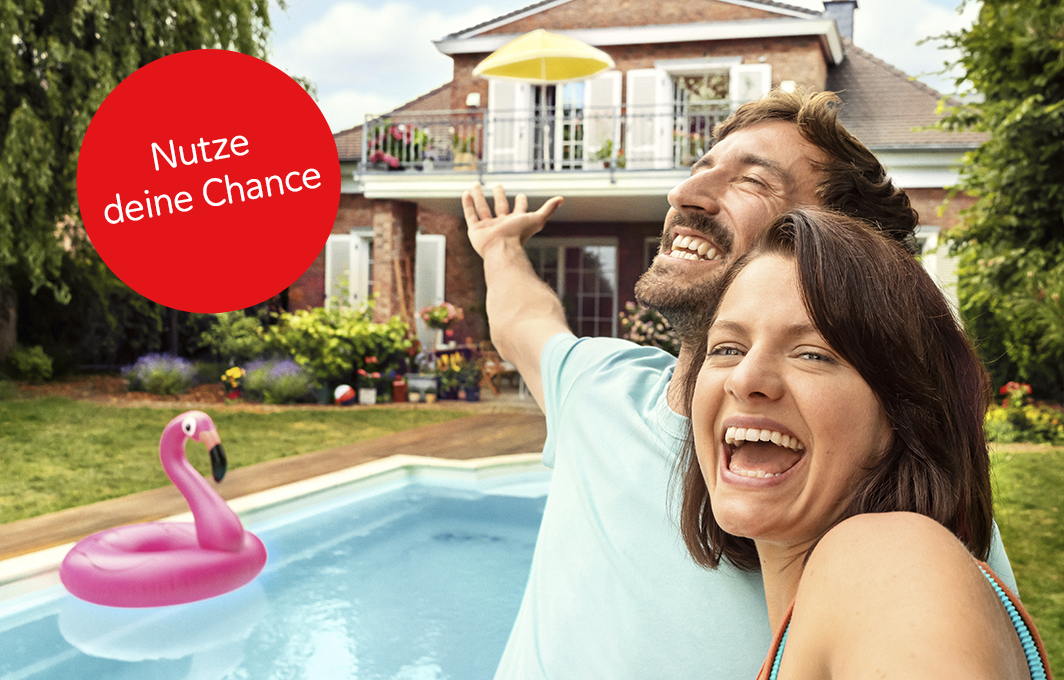 Ein Pärchen macht ein Selfie vor ihrem Haus mit Pool.