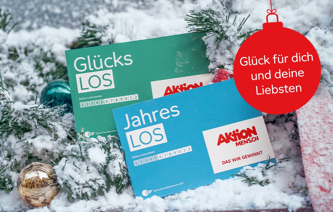 Ein Glücks-Los und ein Jahreslos liegen im Schnee.