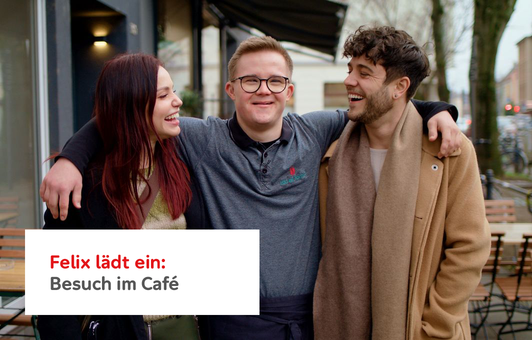Felix hat Downsyndrom. Er steht zwischen Luca und Christina und hat die Arme um deren Schulter gelegt. Alle drei lachen.