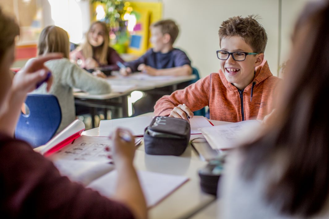 Aufnahme aus einem Klassenzimmer voller Schüler*innen. Der Link führt zu unserer Seite über das Förderprojekt.