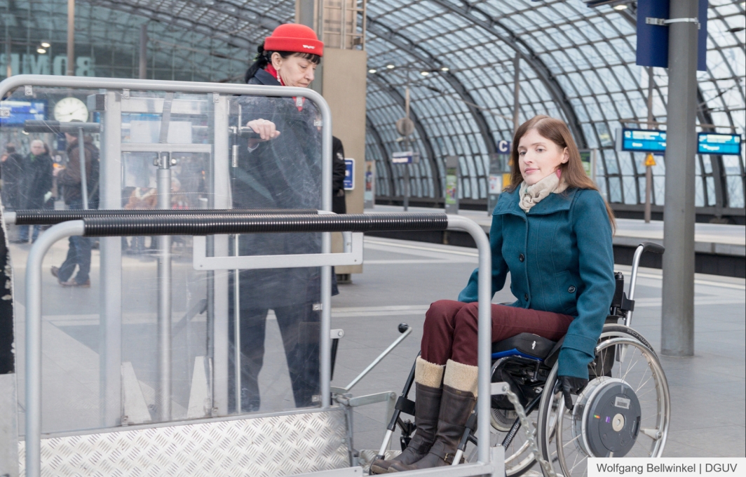 Eine Frau im Rollstuhl nutzt am Bahnsteige eine mobile Einstieghilfe der Deutschen Bahn.