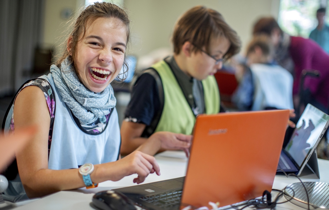 Ein Mädchen arbeitet in einem Schulungsraum am Laptop.