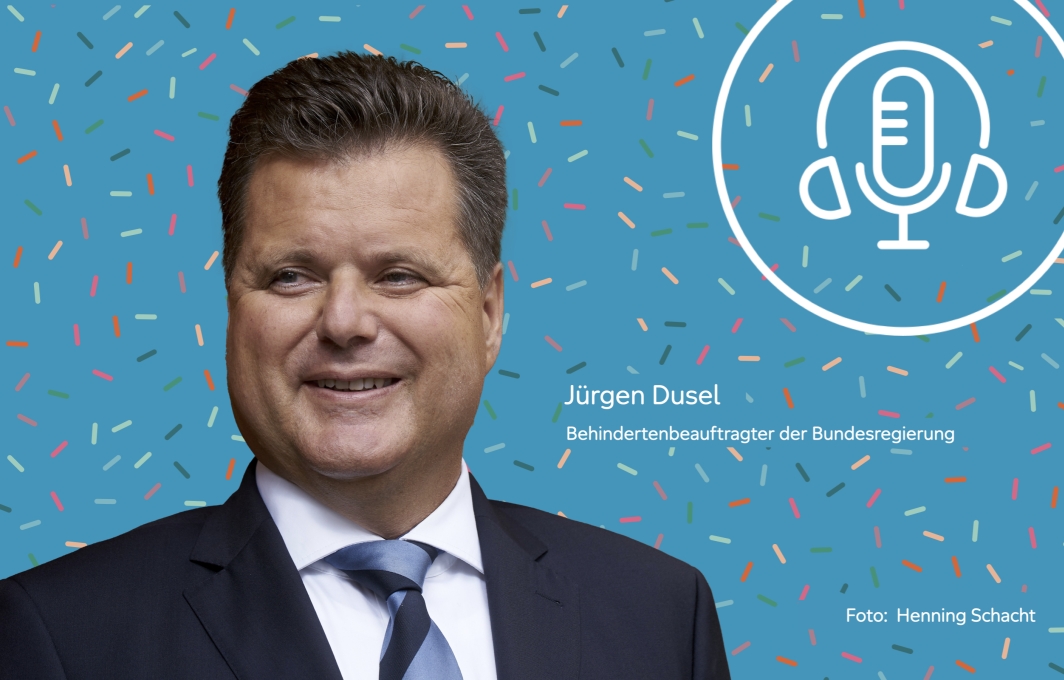 Porträt eines Mannes mit kurzen dunklen Haaren. Er trägt Anzug und Krawatte und lächelt.