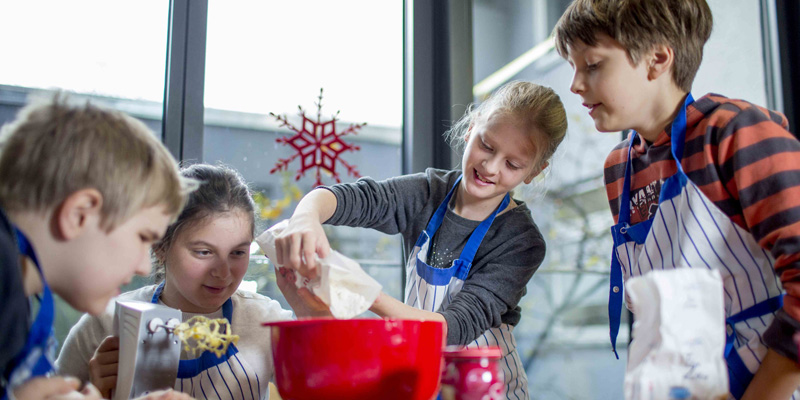 Kinder backen Plätzchen.