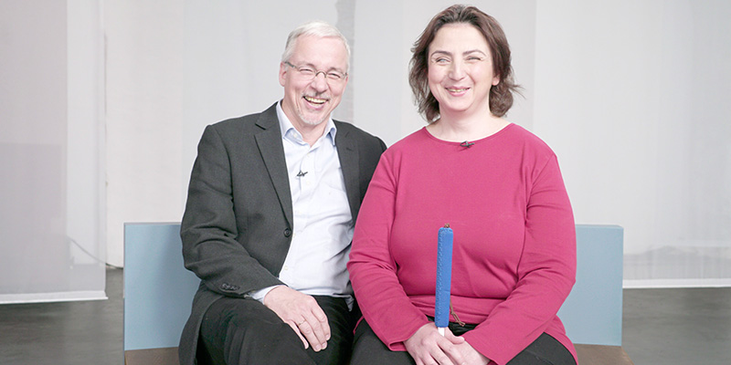 Ein Mann und eine Frau mit Sehbehinderung lachen in die Kamera