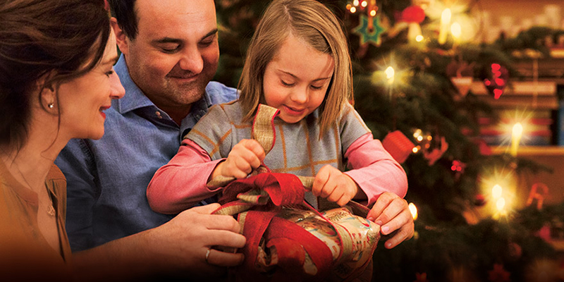 Eine inklusive Familie sitzt am Tannenbaum