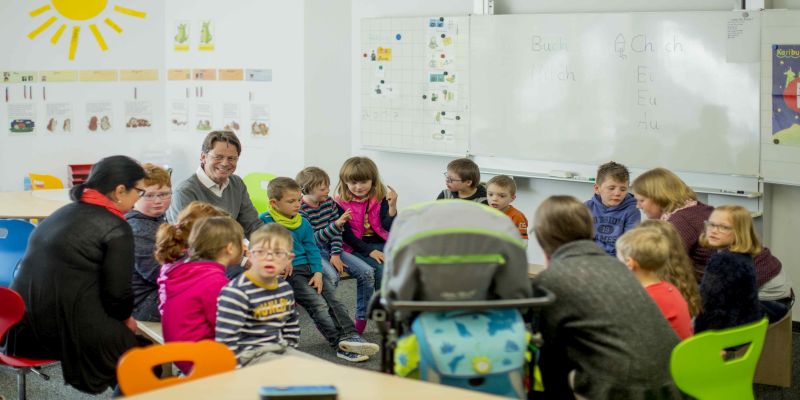 Schüler und Lehrer sitzen im Klassenraum