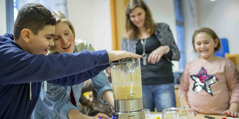 Kinder machen einen Shake mit einem Mixer