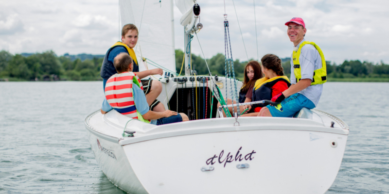 Jungen und Mädchen mit und ohne Behinderung segeln gemeinsam auf dem Chiemsee.