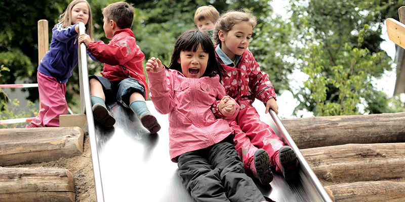 Kinder rutschen eine Rutsche hinunter