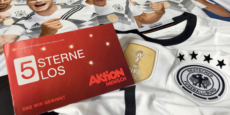 Das 5 Sterne-Los liegt auf einem Trikot und auf einem Poster.