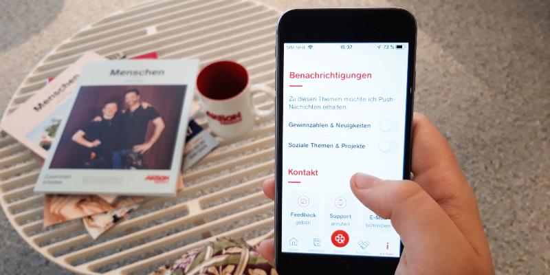 Der Blick auf ein Mobiltelefon, an dem die Auswahl für Benachrichtigungen in der Aktion Mensch-App aufgerufen ist.