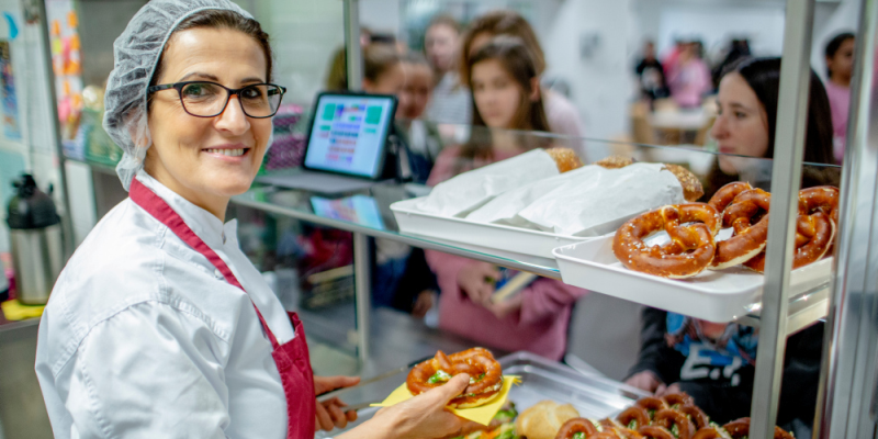 Eine Frau bedient in der Schulkantine