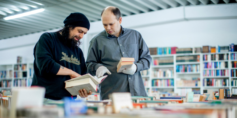 Zwei Männer stöbern im Bücherbasar.