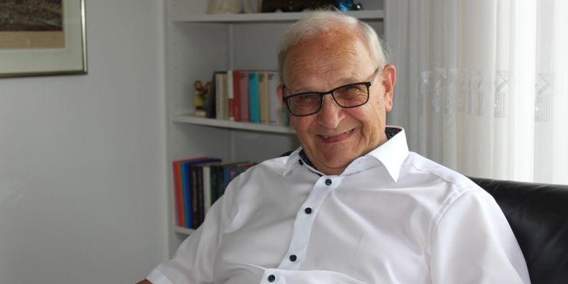 Gewinner Franz sitzt in seinem Wohnzimmer und lächelt in die Kamera.