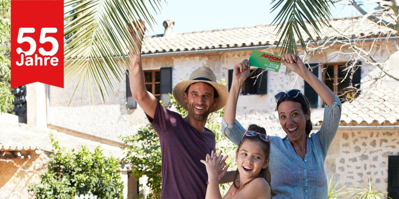 Eine Familie steht jubelnd vor einer Finca.