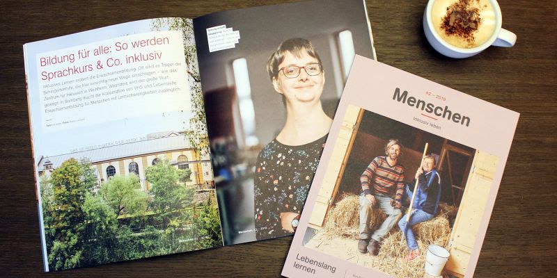 Das aktuelle Magazin liegt aufgeschlagen auf einem Holztisch.