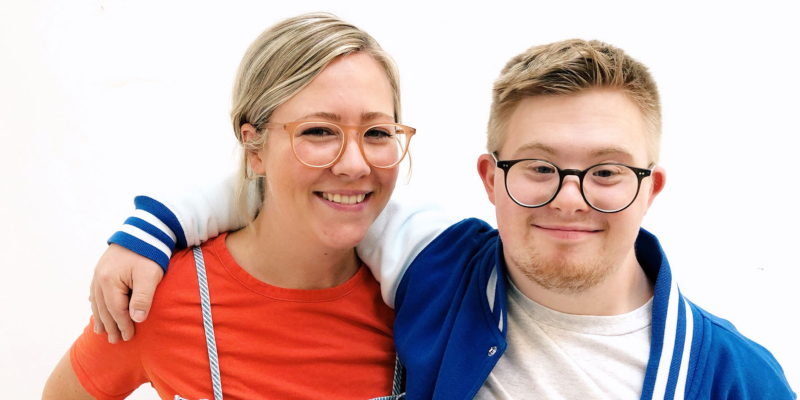 Die Geschwister Tabea und Marian lächeln Arm in Arm in die Kamera.