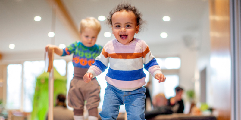 Zwei Kleinkinder spielen gemeinsam im Indoorspielplatz.