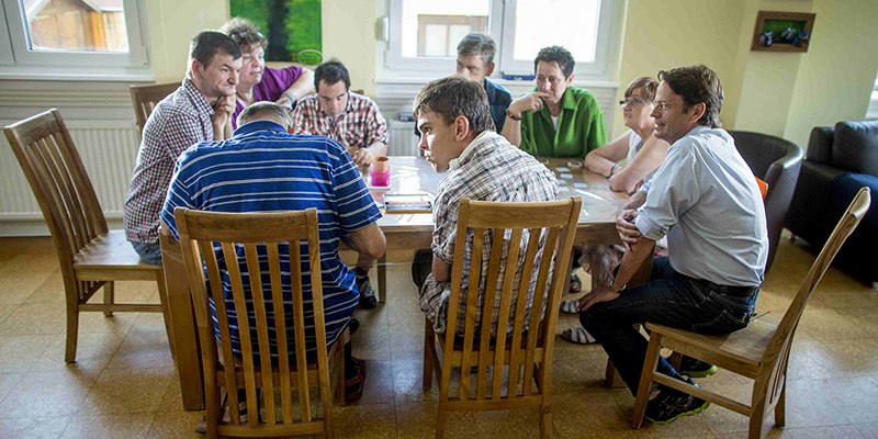Männer und Frauen sitzen an einem Tisch